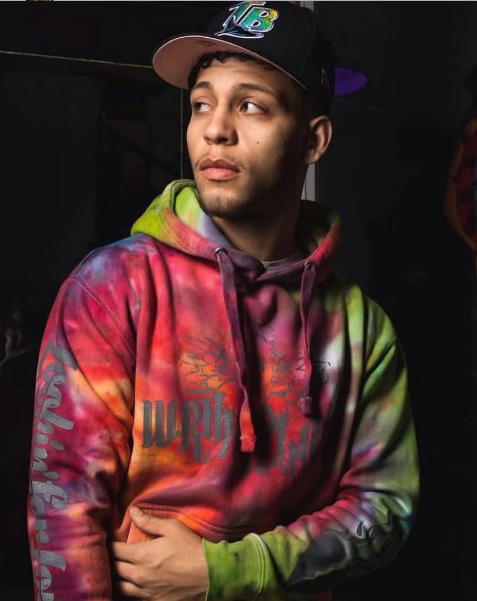 Editorial studio portrait of Rome Rizzo in a tie-dye hoodie and cap