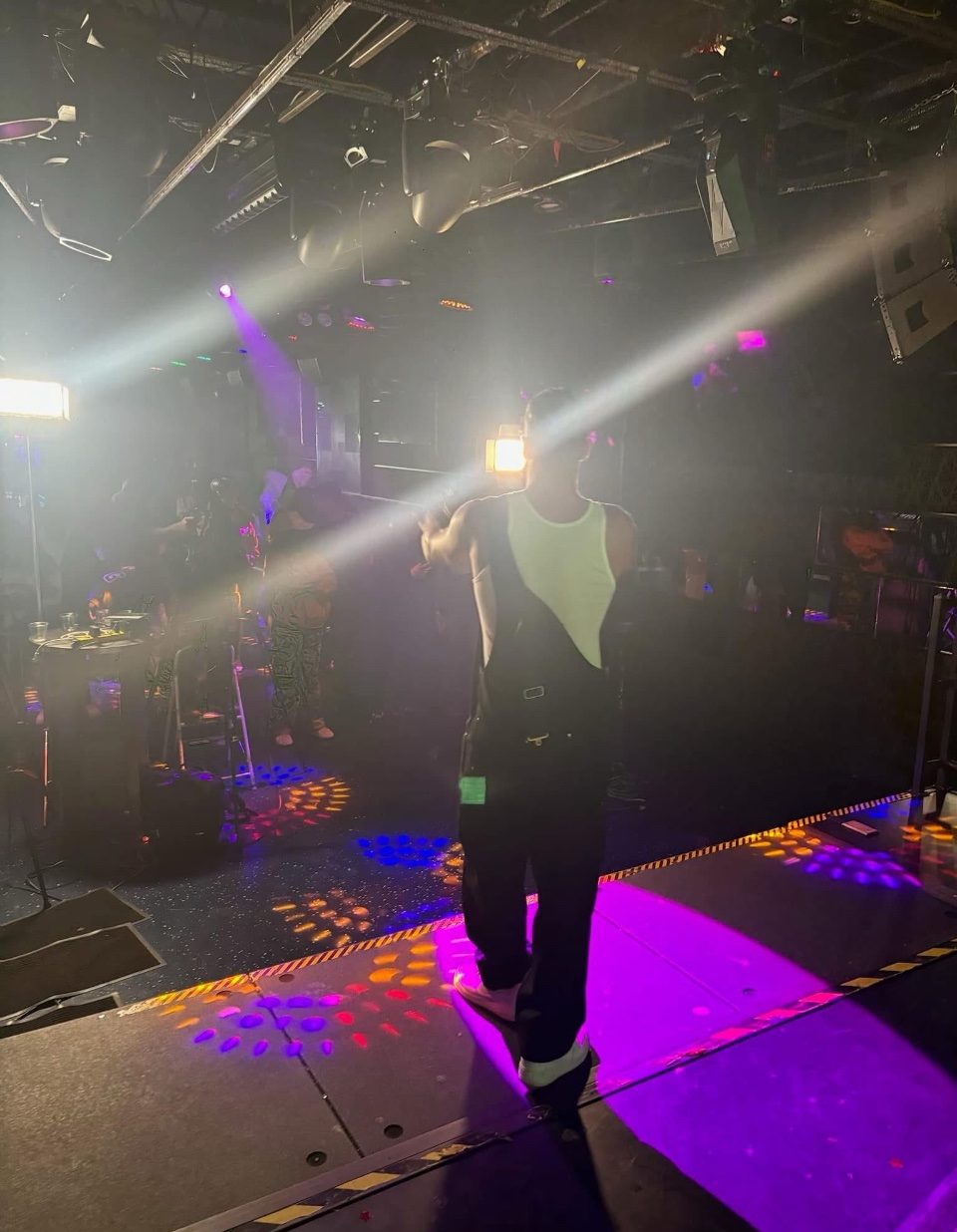 Rome Rizzo performing on stage under colored lights